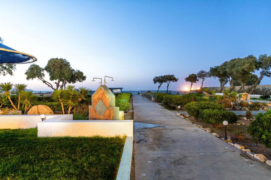 a walkway leading to a garden with a building at Hotel Tsagarakis Beach in Amoudara Herakliou