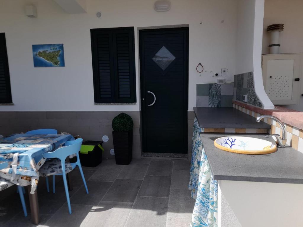 a kitchen with a counter and a table and a door at casa Marinello in Oliveri