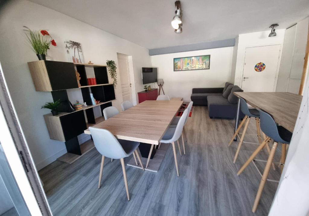 comedor y sala de estar con mesa de madera y sillas en Appartement entier Ascain, 3 pièces, 4 personnes entre la Rhune et St Jean de Luz, en Ascain