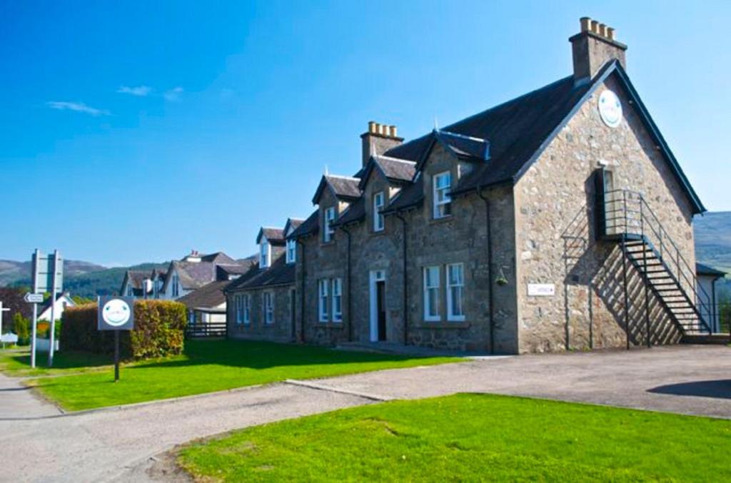 un gran edificio de ladrillo con un reloj. en Loch Ness Guest House en Fort Augustus