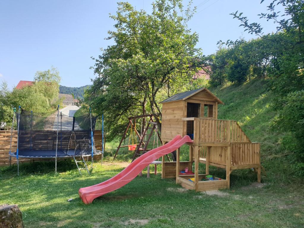 einen Spielplatz mit Rutsche und Spielhaus in der Unterkunft Szczawnica noclegi U Basi in Szczawnica