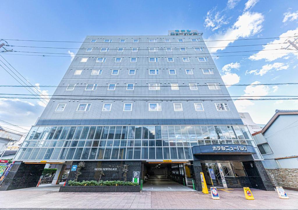 un edificio alto con ventanas de cristal en una calle en Hotel New Palace, en Shingu