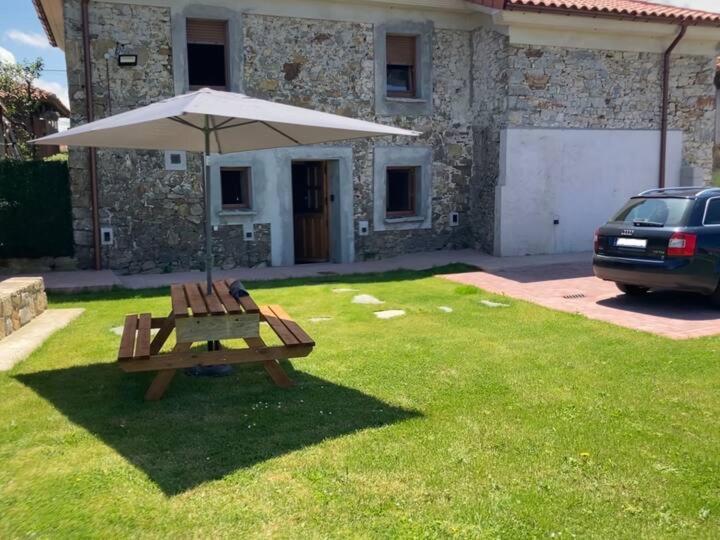 uma mesa de piquenique e um guarda-chuva num quintal em Casa Luis “el Ferre” em Cudillero