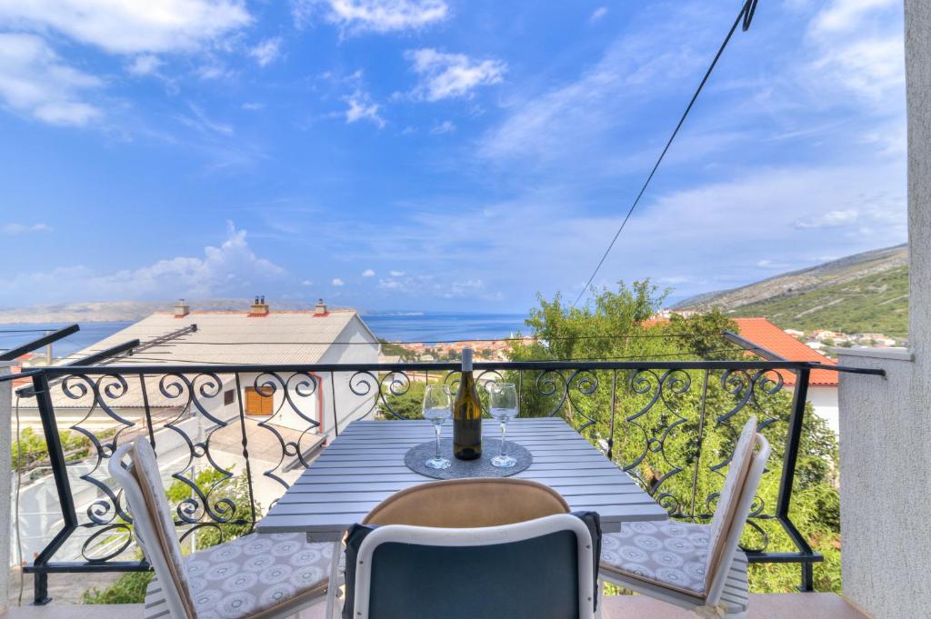 una mesa y sillas en un balcón con vistas al océano en Apartman Sunce, en Senj