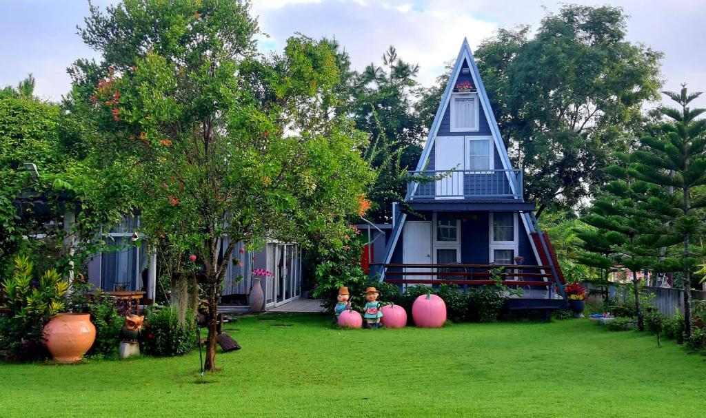 Eine Frau, die im Garten eines Hauses sitzt. in der Unterkunft Korp View House in Wang Nam Khieo