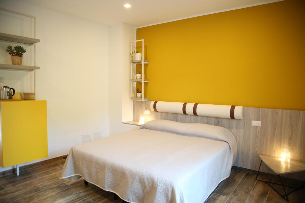 1 dormitorio con 1 cama con pared amarilla en Azienda Agricola Ausono, en Piaggine