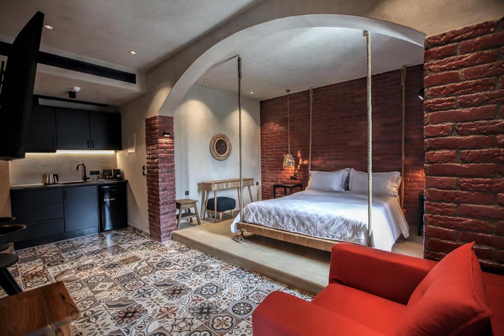 um quarto com uma cama e um sofá vermelho em Meteora Heaven and Earth Kastraki premium suites - Adults Friendly em Kalabaka