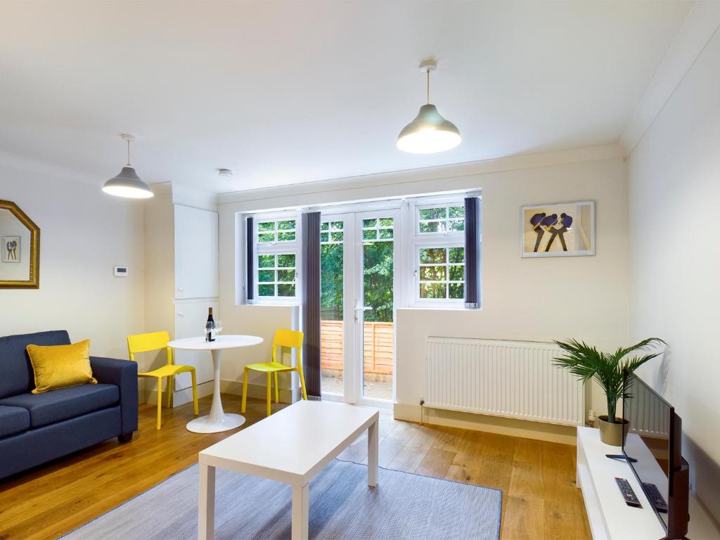 a living room with a blue couch and a table at Redhill town centre apartment by Livingo in Redhill