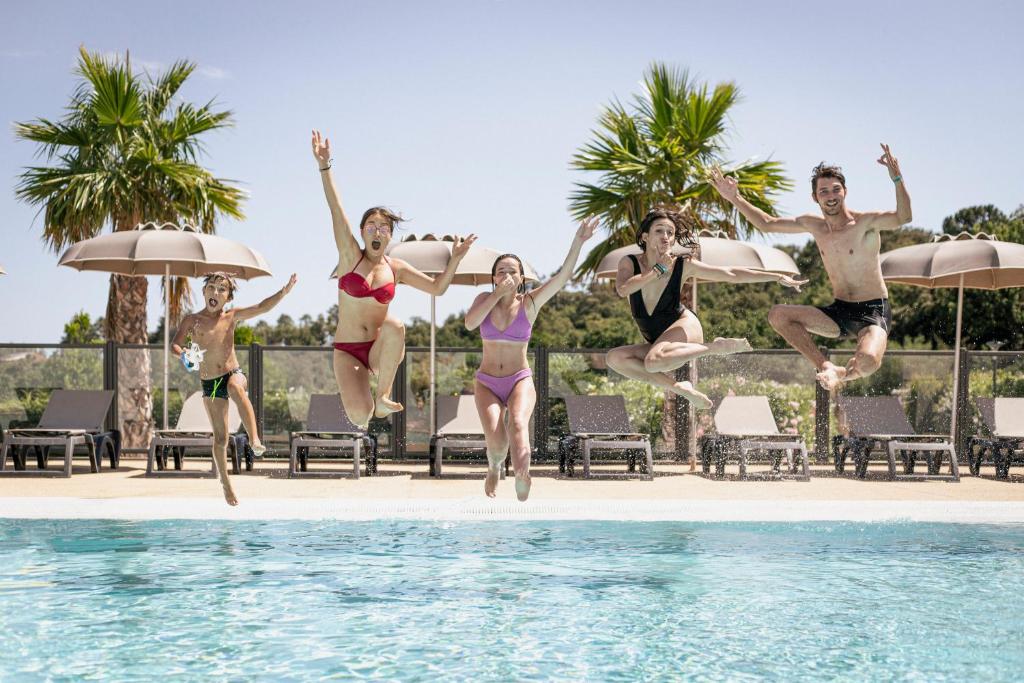 a group of people jumping into a swimming pool at Domaine de Miremer in La Garde-Freinet