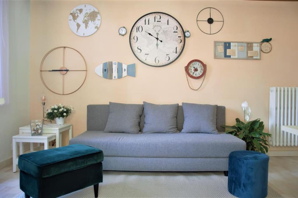 a living room with a couch and clocks on the wall at Casa del Tempo, apt+giardino CITRA 010054-LT-0417 in Santa Margherita Ligure