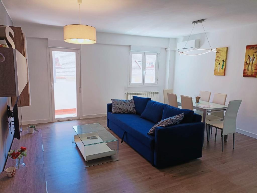 a living room with a blue couch and a table at Apartamento El Torreón, con opción a parking in Zaragoza