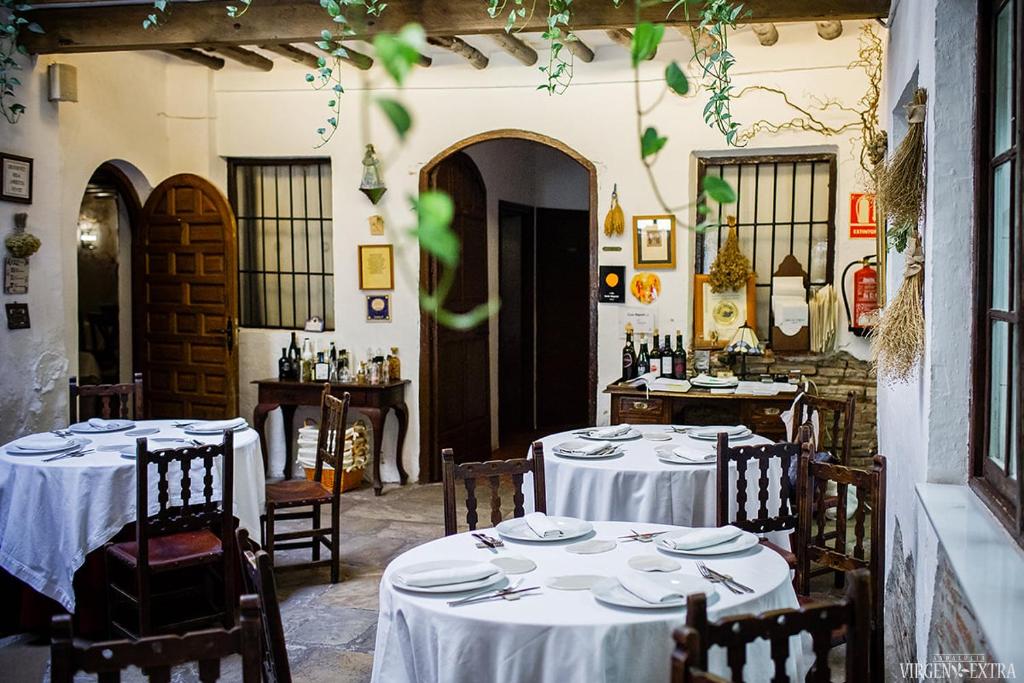 a restaurant with two tables with white tablecloths at Arte de Cozina in Antequera