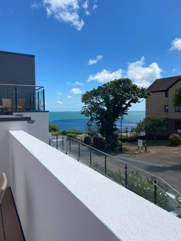 een wit balkon met uitzicht op de oceaan bij The Bay house Apartments , shanklin in Shanklin