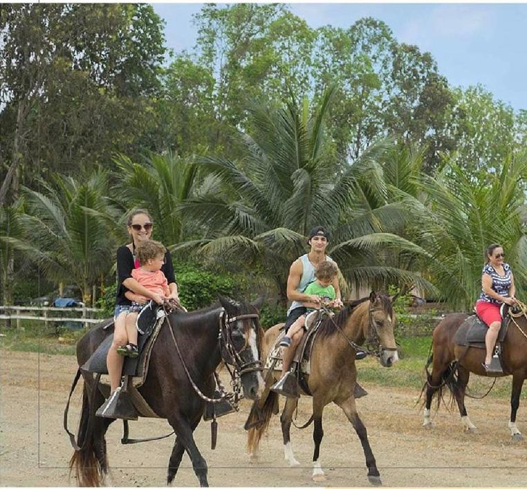 a group of people riding horses with their babies at CAMPO y PLAYA OLON HACIENDAS in Olón