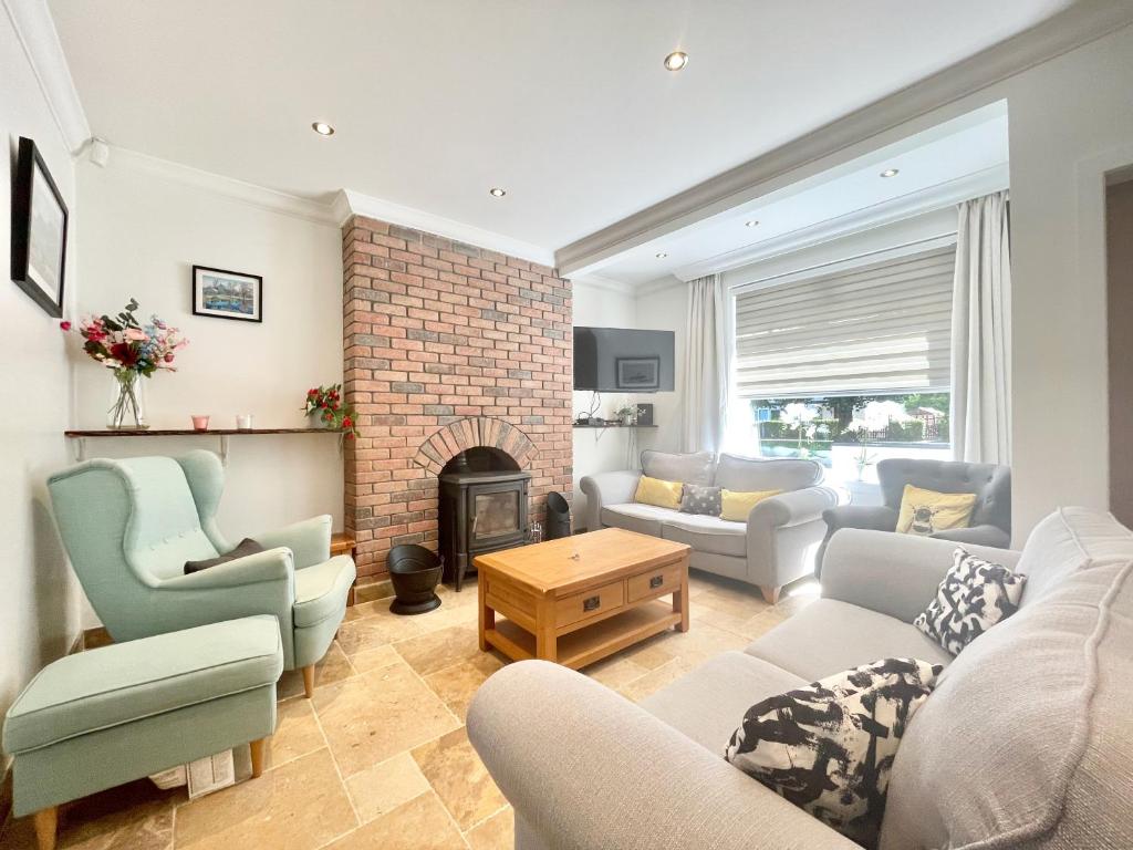 een woonkamer met een bank en een open haard bij Clyde Villa in Glasgow