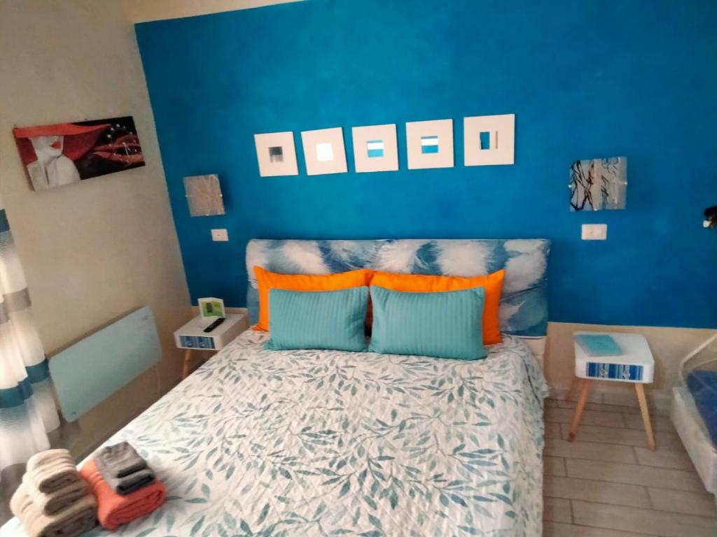 sypialnia z niebieskimi ścianami i łóżkiem z pomarańczowymi poduszkami w obiekcie Il Rifugio dei Colonna casadolcecasa w mieście Marino