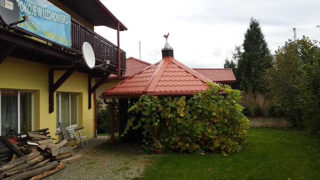 a house with a large bush next to a building at Pokoje w Uzdrowisku in Przerzeczyn-Zdrój