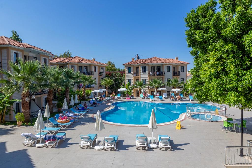 a large swimming pool with chairs and umbrellas at Marcan Beach Hotel in Oludeniz