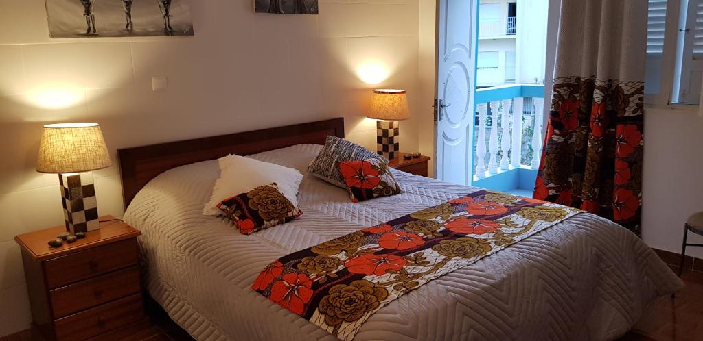 a bedroom with a bed with two lamps and a window at Casa Au Bonheur des Randonneurs in Ponta do Sol