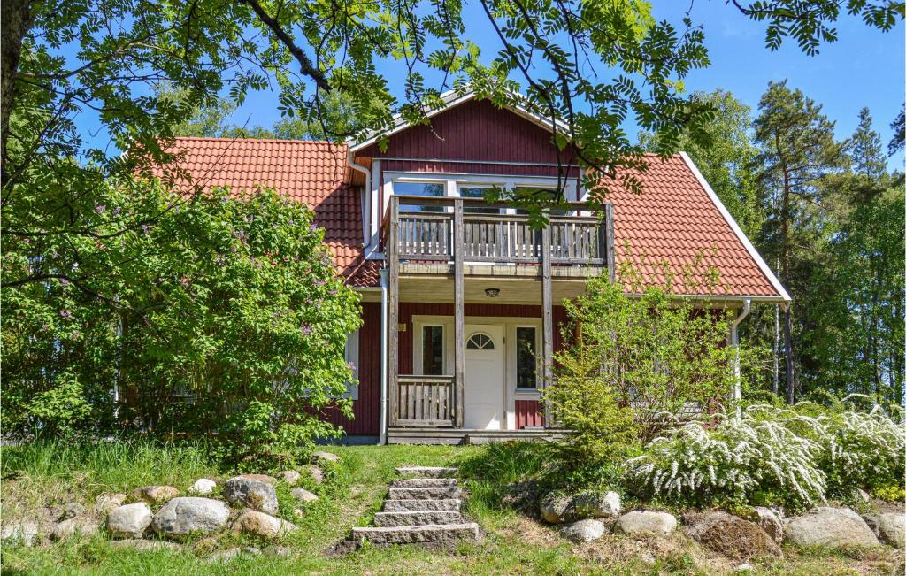 una casa con techo rojo y porche en 4 Bedroom Lovely Home In Mariefred en Mariefred
