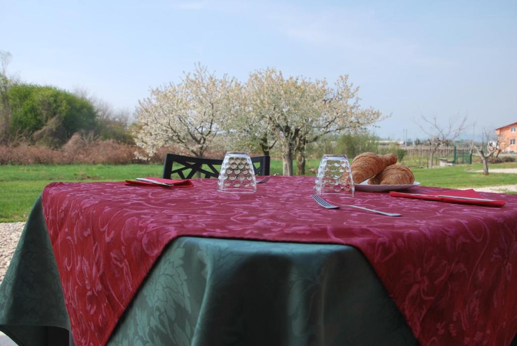 uma mesa com uma toalha de mesa vermelha e pão sobre ela em B&B da Rosy em Lazise