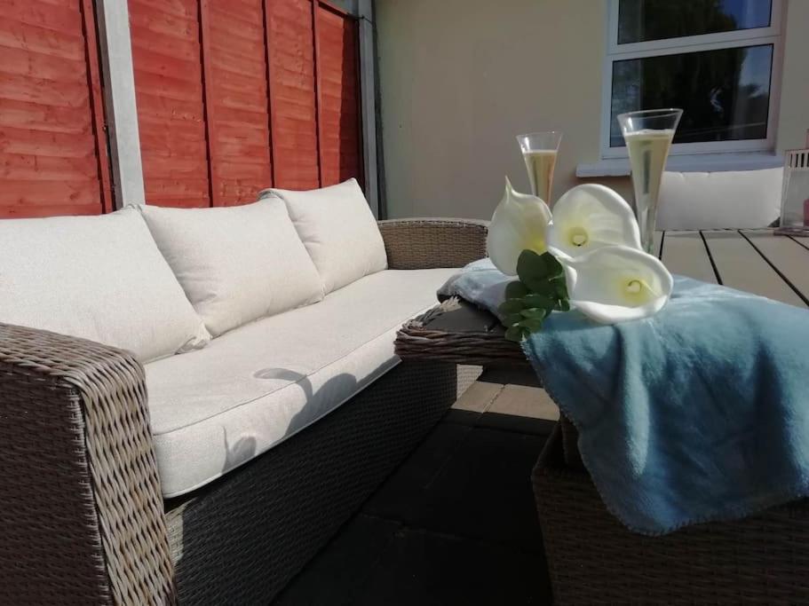 a wicker couch with a blanket and two glasses of champagne at Bovinda Cottage - By the Beach, Bettystown in Bettystown