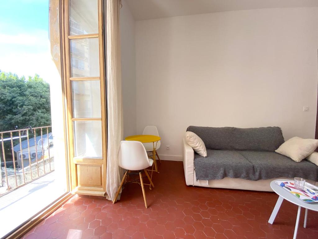 un salon avec un canapé et une grande fenêtre dans l'établissement Belle chambre d hôte Et cuisine hyper centre, à Bastia