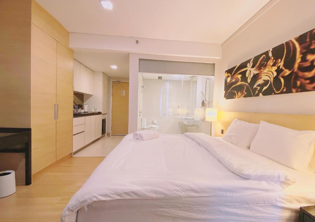 a bedroom with a large white bed in a room at Straits Suite by C Homestay Malacca in Malacca