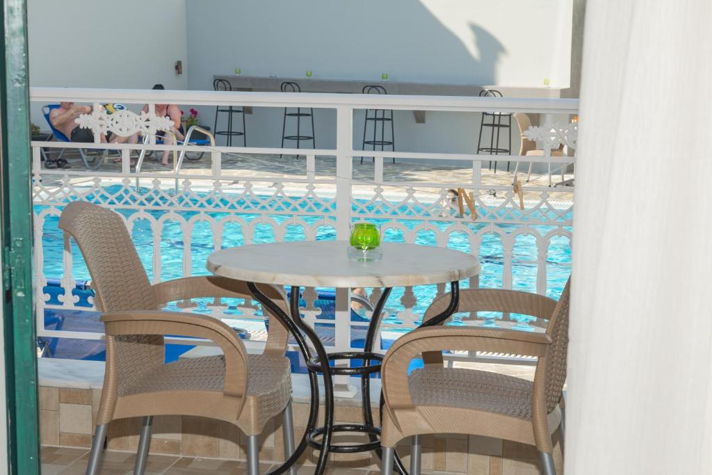 una mesa y sillas junto a una piscina en Villa Krina, en Argassi