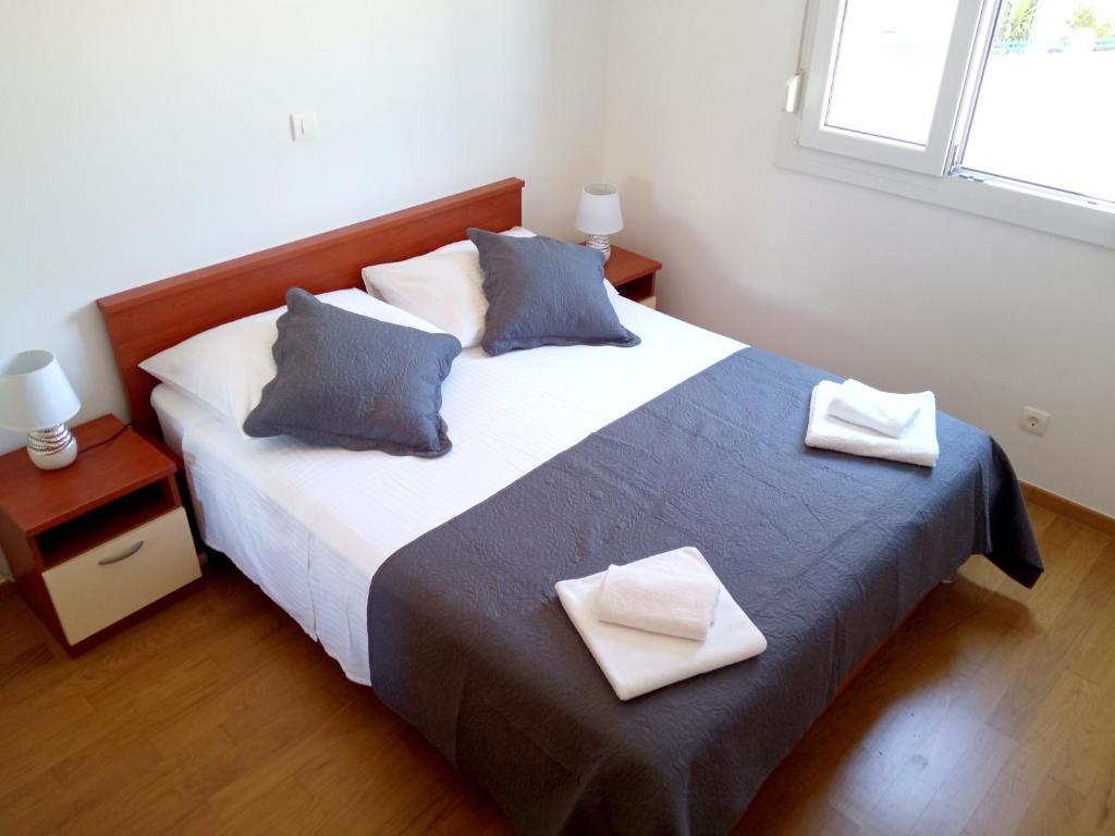 a bedroom with a large bed with two pillows at Great apartment, free parking in the garage, Žnjan in Split