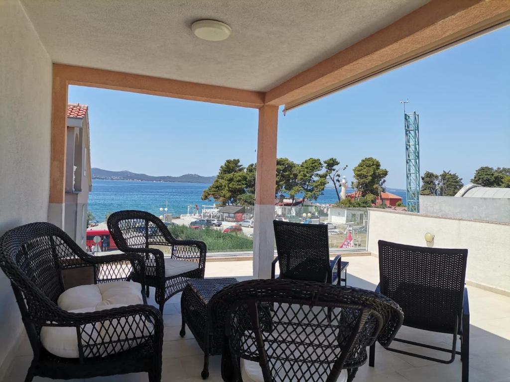 a porch with chairs and a view of the water at Apartment Nino in Zadar