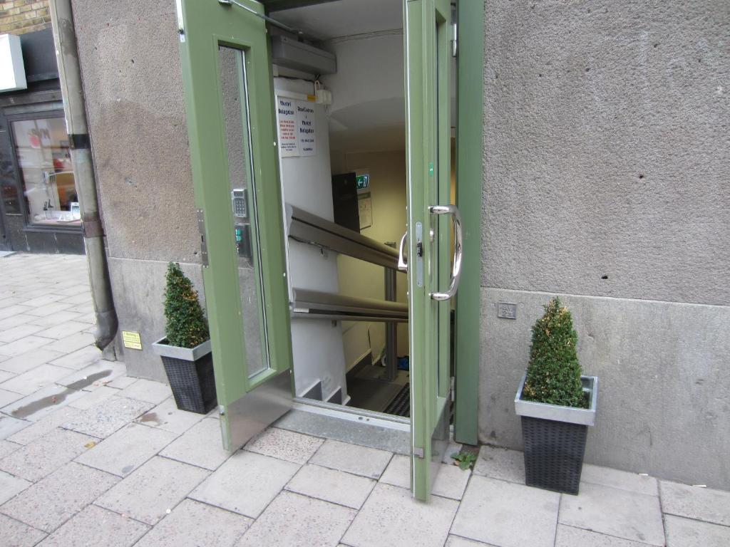 an open door of a building with two plants at Hostel Dalagatan in Stockholm