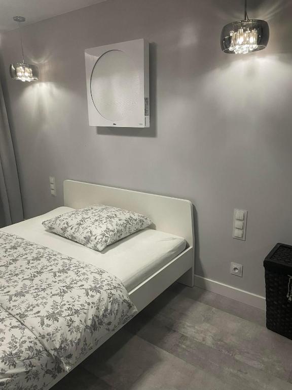 a bedroom with a bed and a mirror on the wall at APARTAMENT Poniatowa in Poniatowa