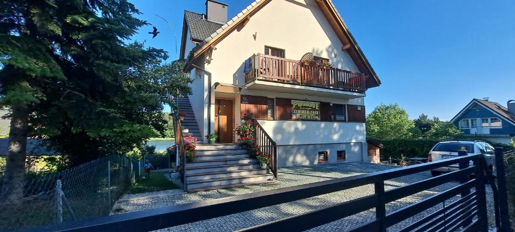 a house with a balcony on top of it at Pokoje gościnne Keja in Wisełka