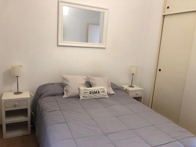1 dormitorio con 1 cama con espejo y 2 mesitas de noche en Departamento Confortable en Corrientes Capital en Corrientes