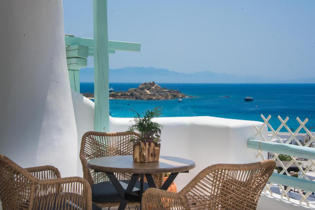 un tavolo e sedie su un balcone con vista sull'oceano di Villa Meliti a Platis Yalos