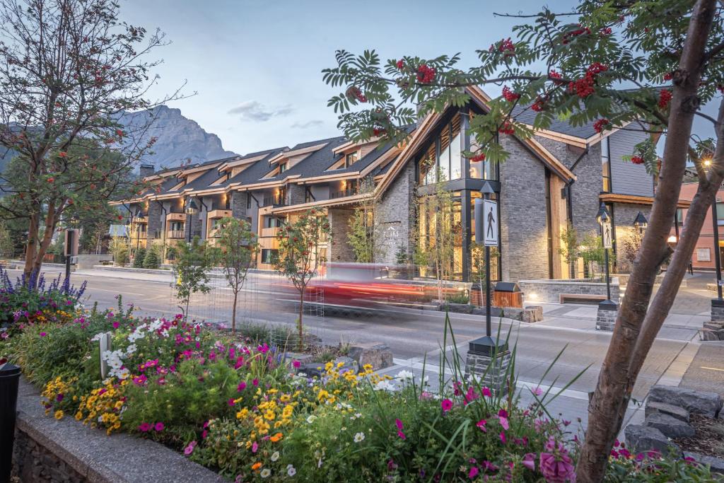 a building with flowers in front of a street at Peaks Hotel and Suites in Banff