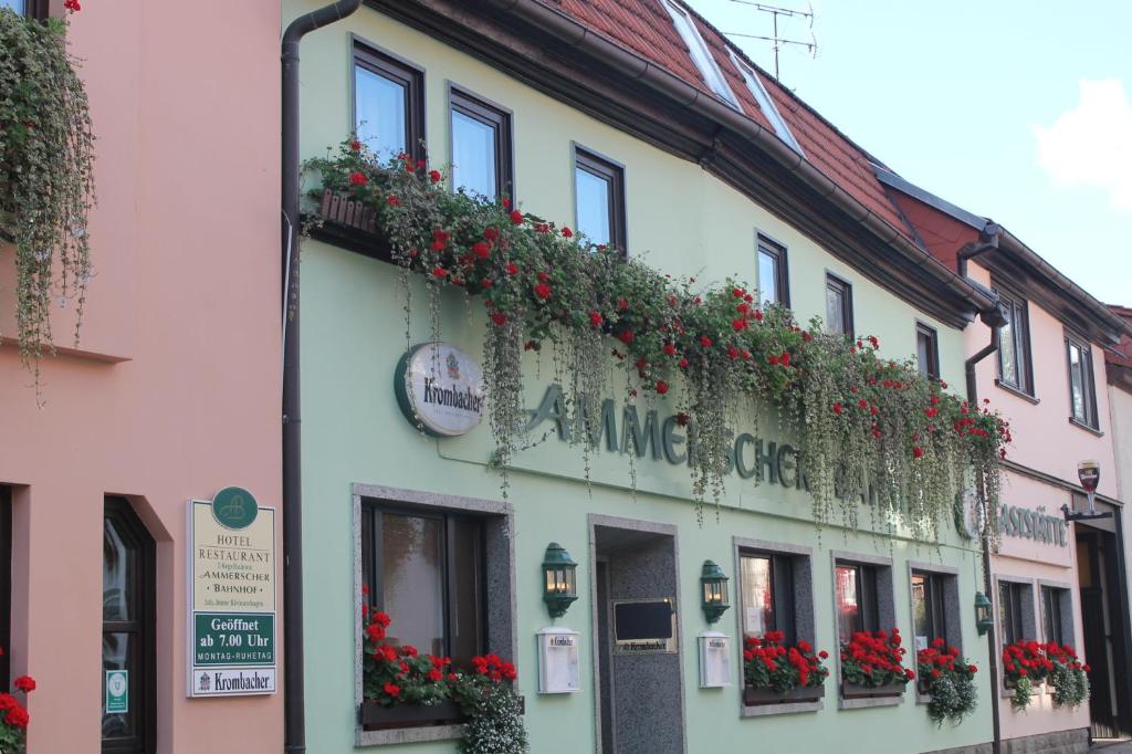 un bâtiment avec des fleurs sur son côté dans l'établissement Ammerscher Bahnhof, à Mühlhausen