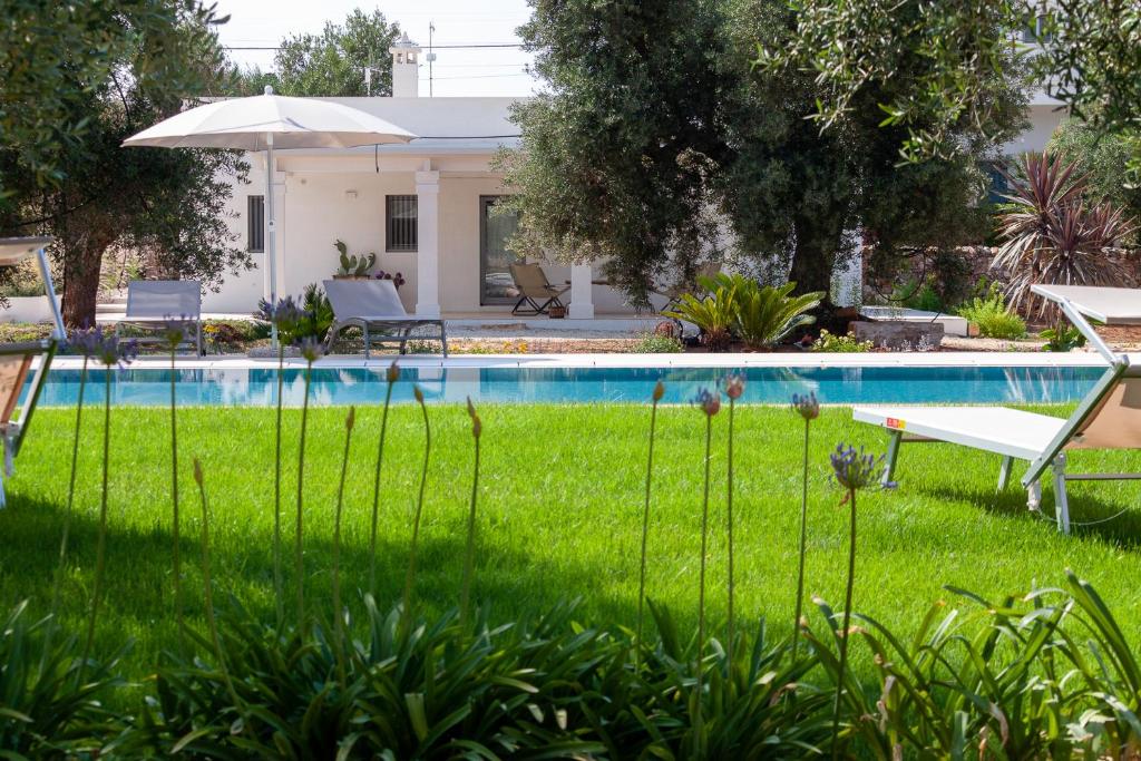 a backyard with a swimming pool and a lawn with plants at Le Dimore Di Speziale in Fasano