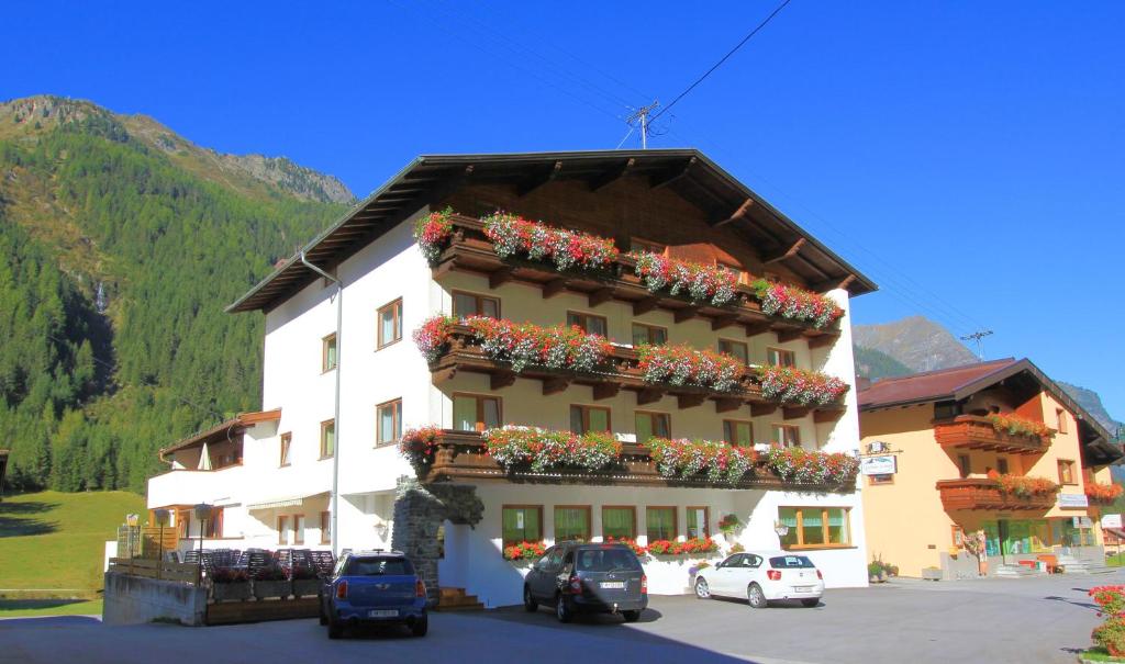 un bâtiment avec des boîtes de fleurs sur son côté dans l'établissement Hotel Pension St. Leonhard, à Sankt Leonhard im Pitztal