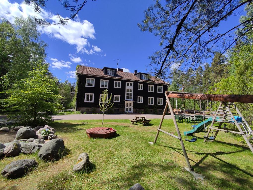 un parque infantil frente a un gran edificio en Villa Karllösa Bed and Breakfast en Målilla