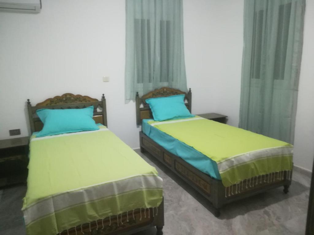 two beds sitting next to each other in a room at Belle Villa Proche Marina in Houmt Souk