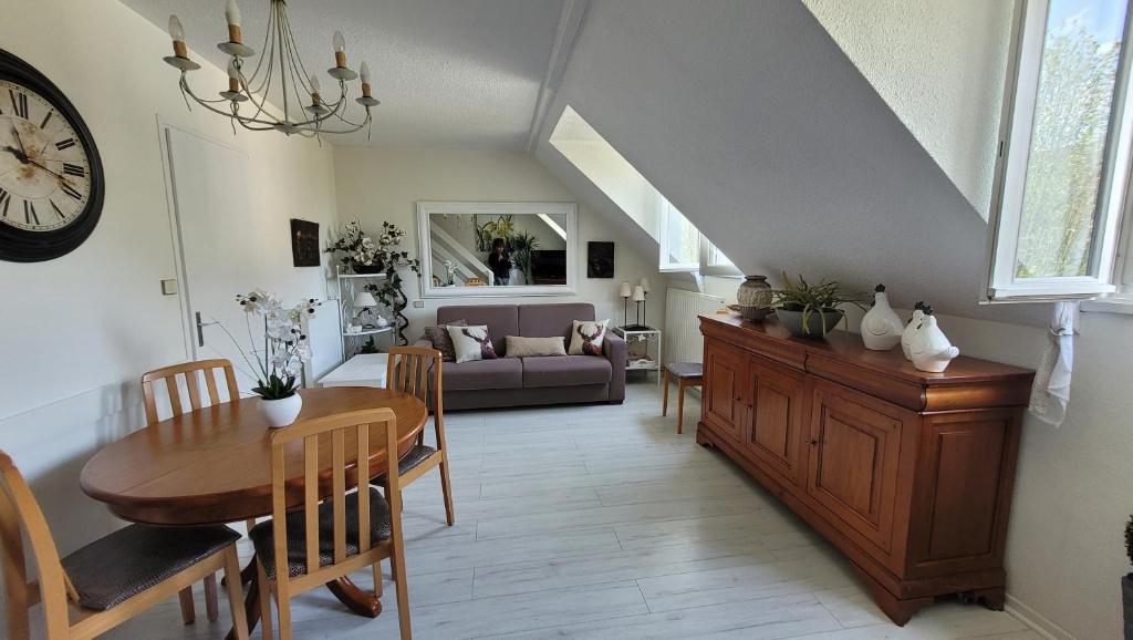 ein Esszimmer und ein Wohnzimmer mit einem Tisch und einer Uhr in der Unterkunft L'imperator in Saint-Mamet