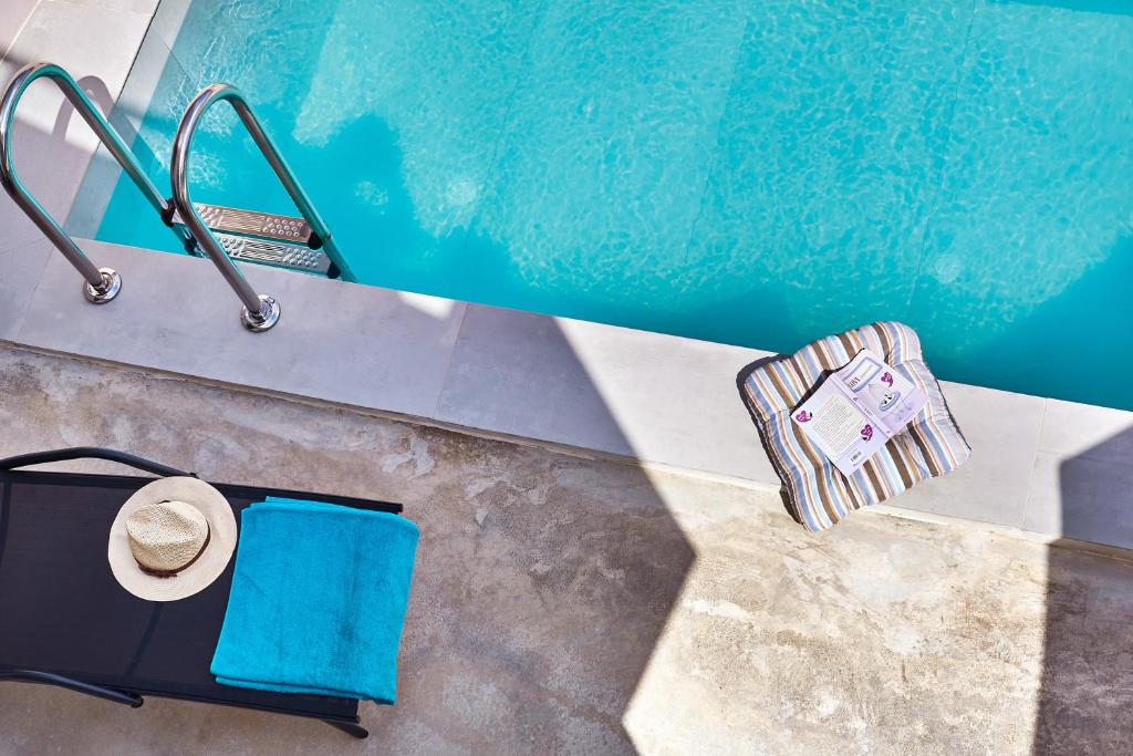 an overhead view of a pool with a hat and towels at Villa Vagelia in  Episkopi (Chania)