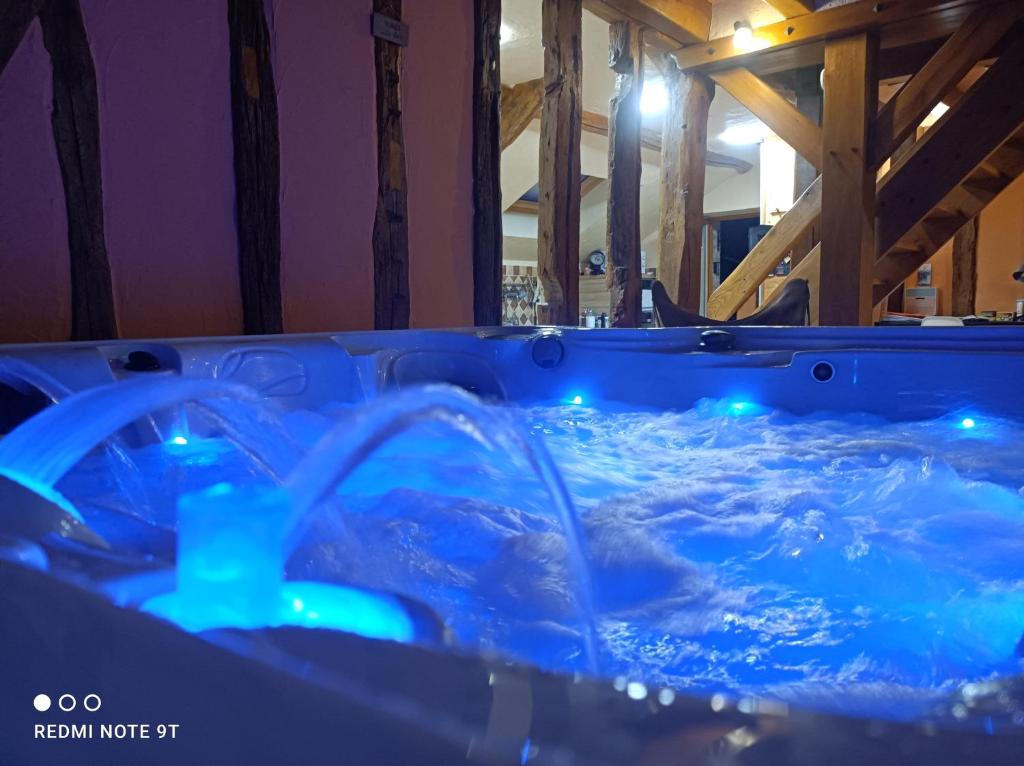 d'un bain à remous rempli d'eau et de lumières bleues. dans l'établissement Sauna & Double Jacuzzi intérieur et sous les étoiles 1h30 Paris, à Ladon