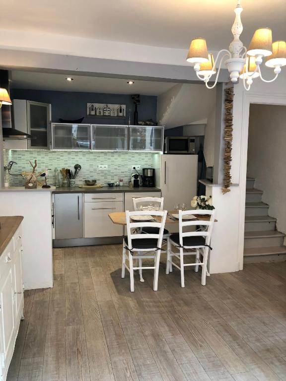 une cuisine avec une table et des chaises dans une pièce dans l'établissement charmante maison de pêcheur typique, à Trouville-sur-Mer