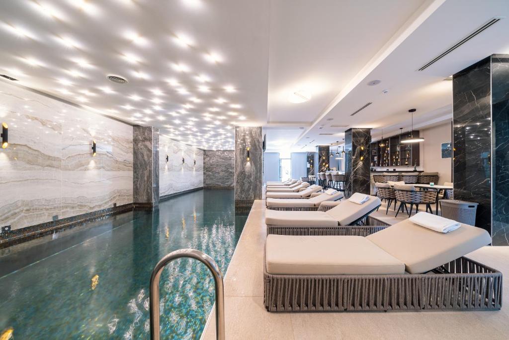 a hotel lobby with a swimming pool and a restaurant at Hotel Millennium by Aycon in Budva