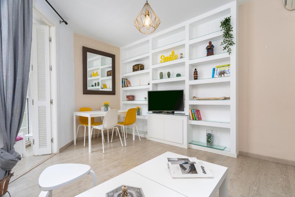 uma sala de estar com prateleiras brancas e uma mesa em Livemálaga Gordon Home em Málaga