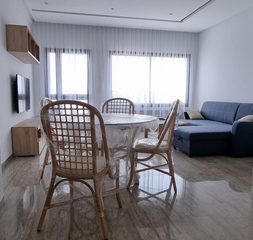 a living room with a table and chairs and a couch at Hammamet vue mer in Hammamet