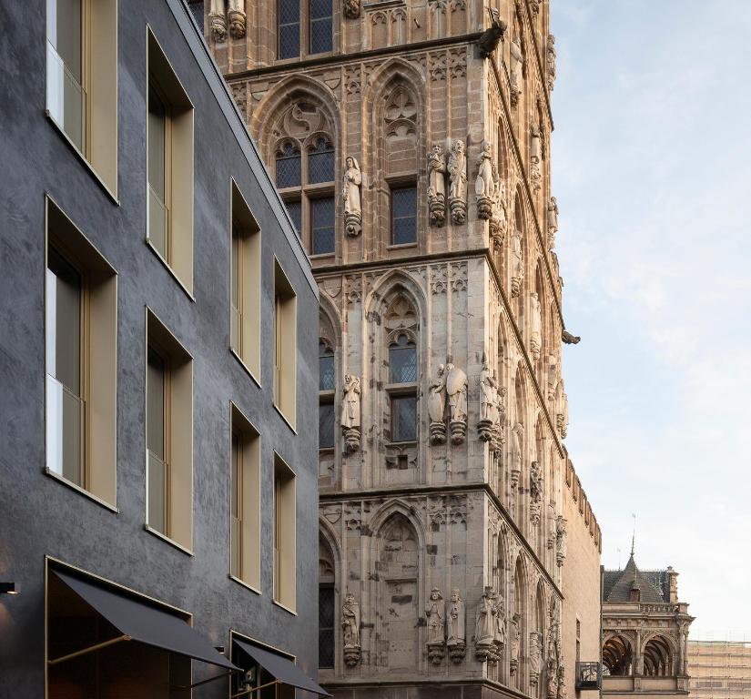 Un grand bâtiment avec des statues sur son côté dans l'établissement Legend Hotel, à Cologne